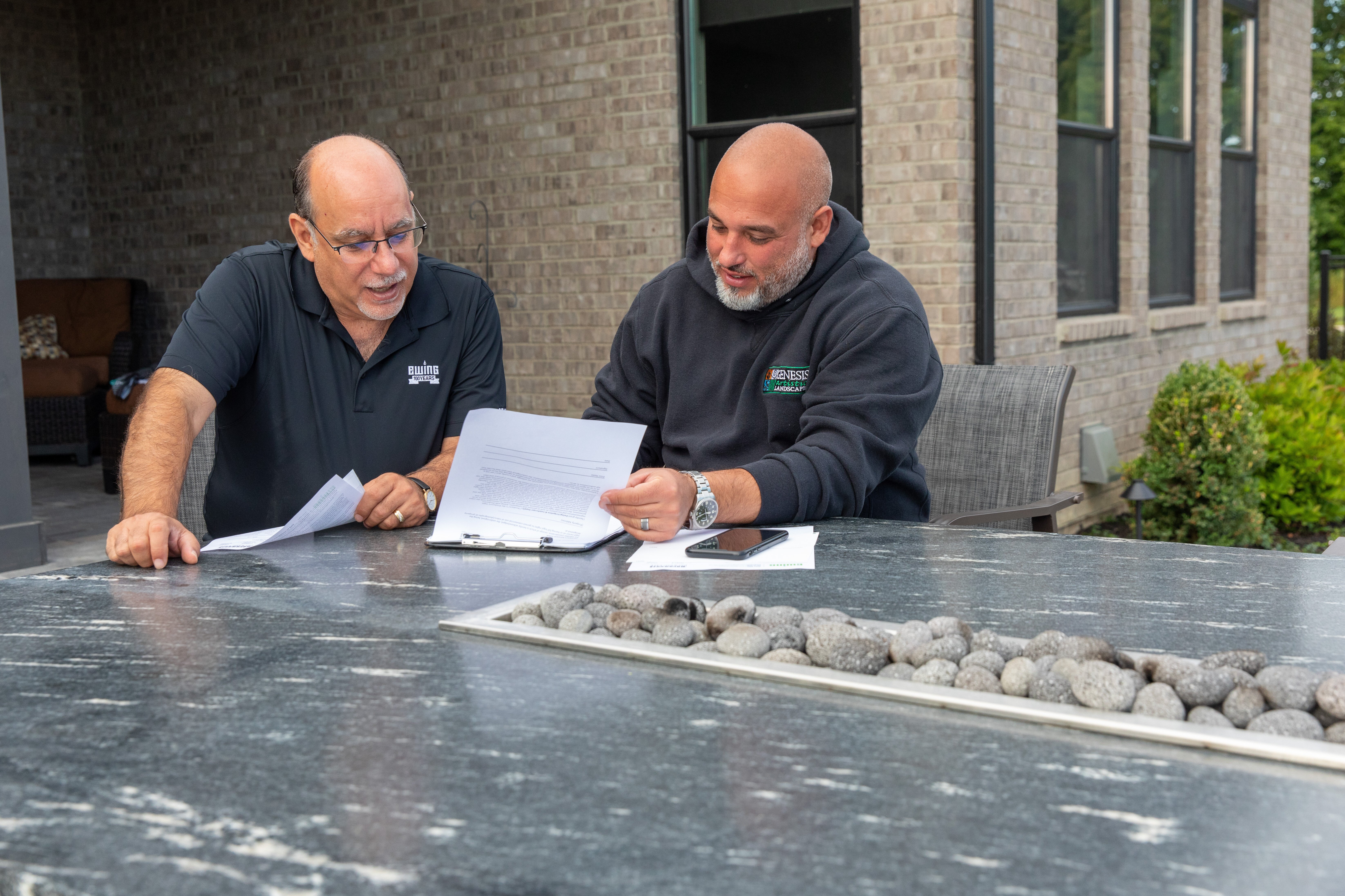 Ewing employee and a customer going through information outside a home (Photo courtesy of Kyle Ellsworth/Ewing Outdoor Supply)