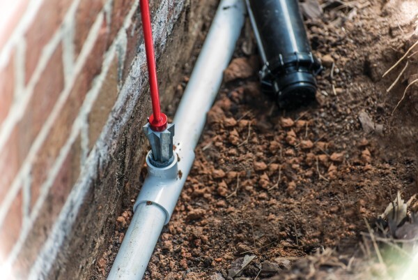 A pipe connecting to a brick wallAI-generated content may be incorrect ...